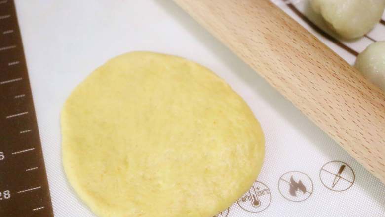 麻糍蜜豆萝卜餐包,取一个松弛好的面团，擀成中间厚，边缘薄的圆形面坯
