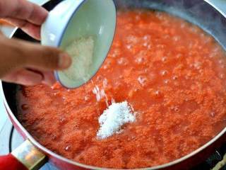 自制番茄酱,炒至西红柿酱汁颜色较为红艳，有点浓稠时倒入白糖，搅拌小火继续煮。