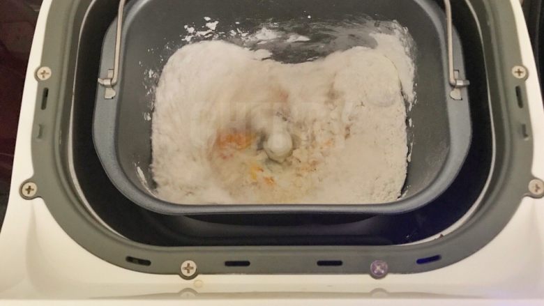 #家有烤箱#黑芝麻豆沙面包,将除了黄油以外的所有材料都倒入面包机里面，开启20分钟的和面模式，