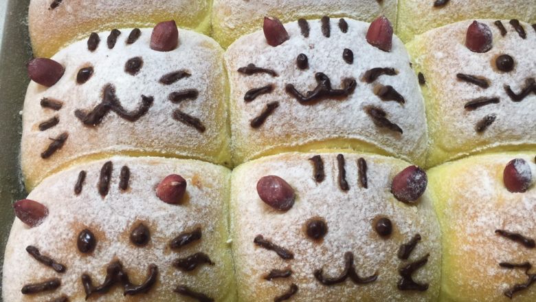 南瓜小米猫咪面包,待面包放凉后用巧克力笔挤上猫咪表情。