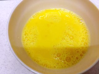 腊肠粒黄金炒饭,鸡蛋打进碗里，加入盐和油，充分搅拌均匀