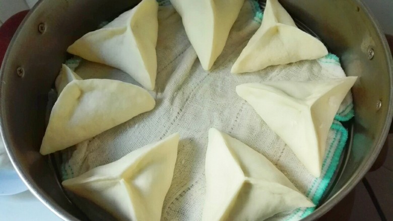 桂香豆沙三角包,电蒸锅里面铺上干净的布(我是新的洗干净的纱布抹布)三角包放进蒸锅发酵