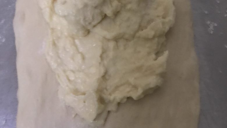 天然酵母榴莲奶酪软欧,取一个白色面团擀开，抹上榴莲奶酪馅，四周不要抹，底部留多点不要抹。
