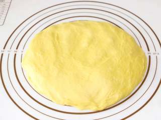 南瓜肉松芝麻包,将发酵好的面团放在揉面垫上按压排气