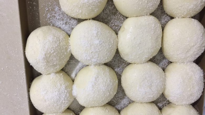 酸奶雪花包（一次发酵法）,发酵好的面团表面刷上水或者蛋液，洒上椰蓉，放进预热好的烤箱
