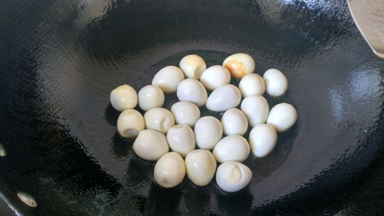 香辣虎皮鹌鹑蛋,将鹌鹑蛋放入锅内，小火煎黄。