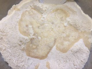 桂花玉米粉重阳糕,将水倒入搅拌均匀的混合面粉中。
