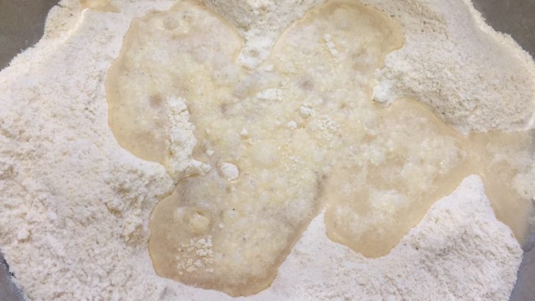 桂花玉米粉重阳糕,将水倒入搅拌均匀的混合面粉中。