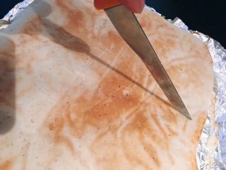 香葱肉松面包卷,烤好的面包倒扣在油纸上，用刀在面包反面轻轻的划上几道