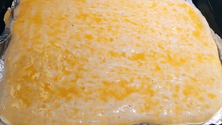 香葱肉松面包卷,发好的面上刷上打散的蛋液