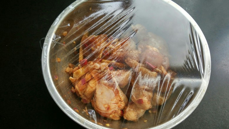 香辣鸡翅根（烤箱版）,用保鲜膜将大碗密封，将鸡翅根放入冰箱冷藏8个小时入味（我一般是提前一晚上腌制好）。