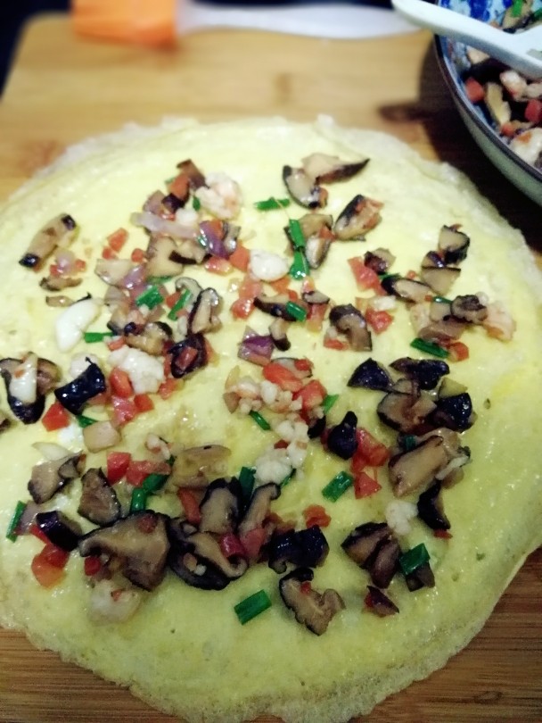 虾仁鸡蛋卷,把炒好的馅料放在鸡蛋饼上面整理均匀
