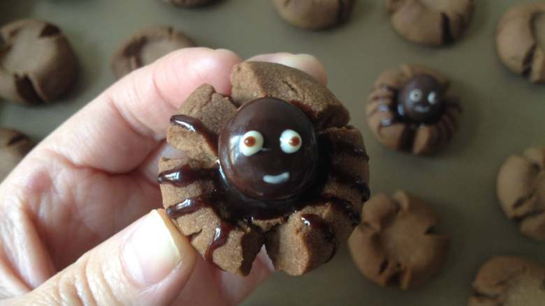 蜘蛛可可饼干,最后用牙签蘸少许巧克力酱在眼白中点出眼珠，再用白巧克力画出小嘴就完成啦，要做几个随意哈