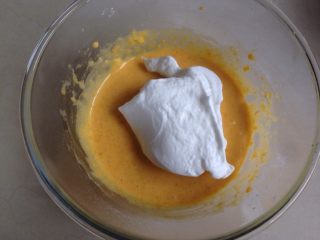 南瓜戚风蛋糕,取三分之一打发好的蛋白霜入蛋黄糊里，用刮刀从底部向上翻拌均匀