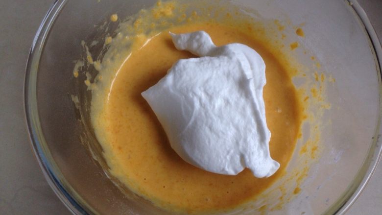 南瓜戚风蛋糕,取三分之一打发好的蛋白霜入蛋黄糊里，用刮刀从底部向上翻拌均匀