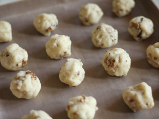 中式点心:传统桃酥,将面团分成30克左右的小面团，放入铺了油纸的烤盘中。