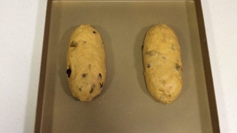 南瓜软欧包,整理成橄榄形状，放入不沾烤盘上。（其实一次放3个面包是可以放得下，但为了面包不连在一起，我分开了放了，所以这里就只出现了两个面包）