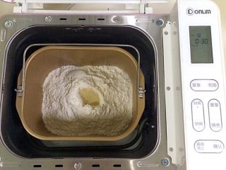 南瓜软欧包,在面包机桶内加入牛奶、南瓜泥，细砂糖和盐对角放入，接着倒入全麦面粉和高筋面粉，在面粉上挖个洞，加入酵母粉（除黄油以外的材料，按照先液体后粉类的顺序），启动面包机和面功能30分钟。