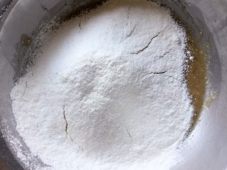 核桃酥～#中式点心#,筛入低筋面粉、苏打粉和泡打粉的混合物。