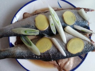 陈醋青鱼,在鱼的身上撒盐抹均匀，葱姜片放在鱼背上去腥腌制入味15~20分钟