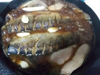陈醋青鱼,倒入2大勺陈醋、酱油适量、白开水没过鱼身，开大火烧开。