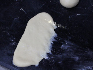 一次性发酵香葱芝士面包,擀成椭圆形长片，反过来，光面朝下，如图，一侧压几下。