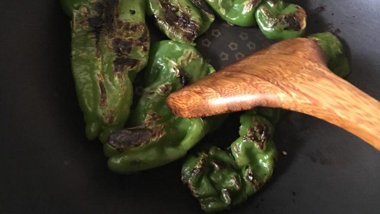 虎皮青椒,期间可以用锅铲轻轻按压表皮炒均匀。