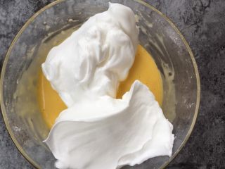 养乐多戚风蛋糕,取三分之一蛋白糊加入蛋黄糊中，用刮刀搅拌均匀。注意搅拌的手法最好是翻拌的手法，或是画Z的搅拌手法。搅拌至看不见蛋白糊的状态。 