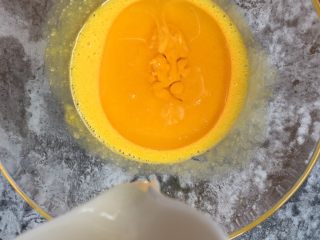 养乐多戚风蛋糕,倒入50克玉米油用蛋抽搅拌至乳化状态。