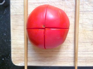 莲花番茄蛋,在番茄左右各放一根筷子，横竖各切一刀。