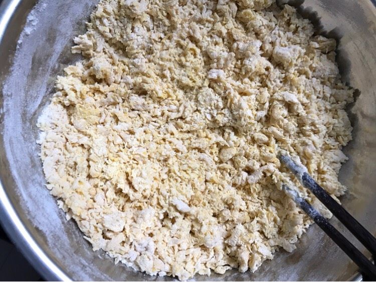南瓜豆沙包,用筷子搅拌成棉絮状，直到没有干面粉，如果不够少量多次的添加南瓜泥