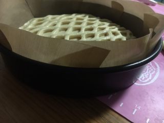 网纹果酱夹心面包,移入8寸的烤盘，为防粘又垫了油布，如是不沾烤盘就不必垫了