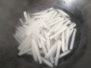 牛肉筷子萝卜,再烧开焯水，将萝卜条煮软煮熟后捞起沥干备用；