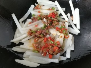 牛肉筷子萝卜,再将炒好的牛肉丁倒一半进去炒均匀；