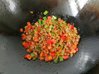 牛肉筷子萝卜,接着倒入青红椒碎丁炒一下，再调入少许生抽、胡椒与鸡精炒均后盛起来；