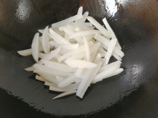 牛肉筷子萝卜,将锅洗净，调入适量油，下萝卜条炒几下；