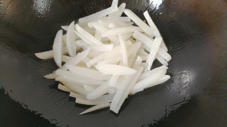 牛肉筷子萝卜,将锅洗净，调入适量油，下萝卜条炒几下；