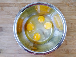 毛蚶子摊鸡蛋,鸡蛋打入盆中。