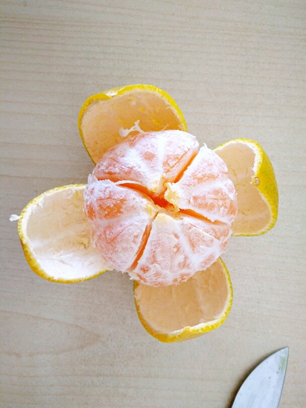 橘子罐头,用水果刀在外皮划十字，然后再慢慢剥开皮，小心刀不要切的太深，不要把果肉切破了。