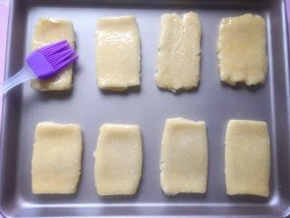 芝麻咸酥饼,将做好的酥饼摆在不粘烤盘中，表面刷上一层薄薄的蛋液。