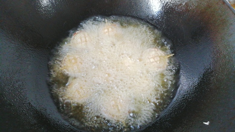 香菇素“鲍鱼”,炸至微黄后翻面将另一面也炸好，炸好后捞出控油装盘；