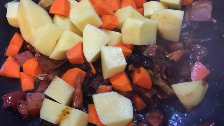 酱香肘子烩土豆盖浇饭,将土豆和胡萝卜加入锅中翻炒