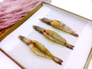 芝士焗大虾,烤盘底下铺上油纸，把腌制好的虾放在烤盘里。