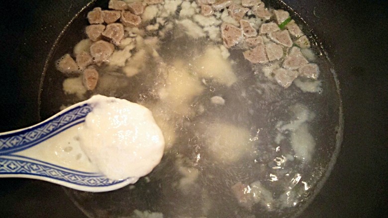 暖心牛肉面疙瘩汤,用勺子勺一点面糊放入煮沸的水中，直到面糊勺完。