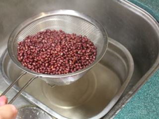 红豆饭,再滾起後，将水倒掉，紅豆冲一下冷水。