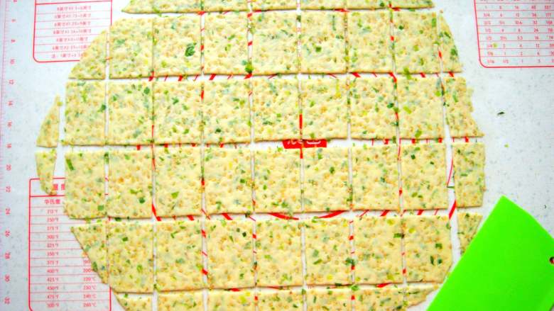 芝麻香葱饼干,用刮板分切成均匀的小块。（余下的边角料再和成面团擀薄片）