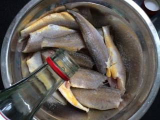 五香酥鱼,放入适量白酒，拌匀腌制1小时，备用。
