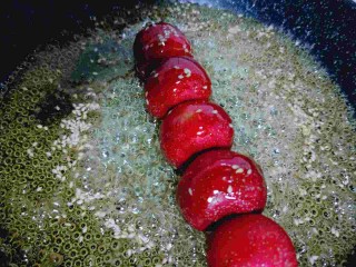 #儿时的记忆#冰糖葫芦,取一根串好的糖葫芦，再糖锅里裹来裹去，使每个山楂都裹满糖，依次做完。