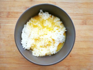 鸡蛋火腿米饭杯~,把蛋液倒入米饭中，用筷子搅拌，让蛋液包裹着米饭粒，