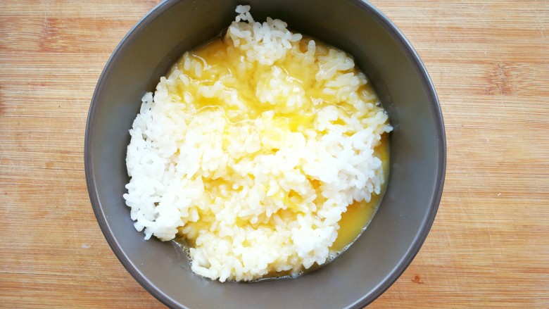 鸡蛋火腿米饭杯~,把蛋液倒入米饭中，用筷子搅拌，让蛋液包裹着米饭粒，